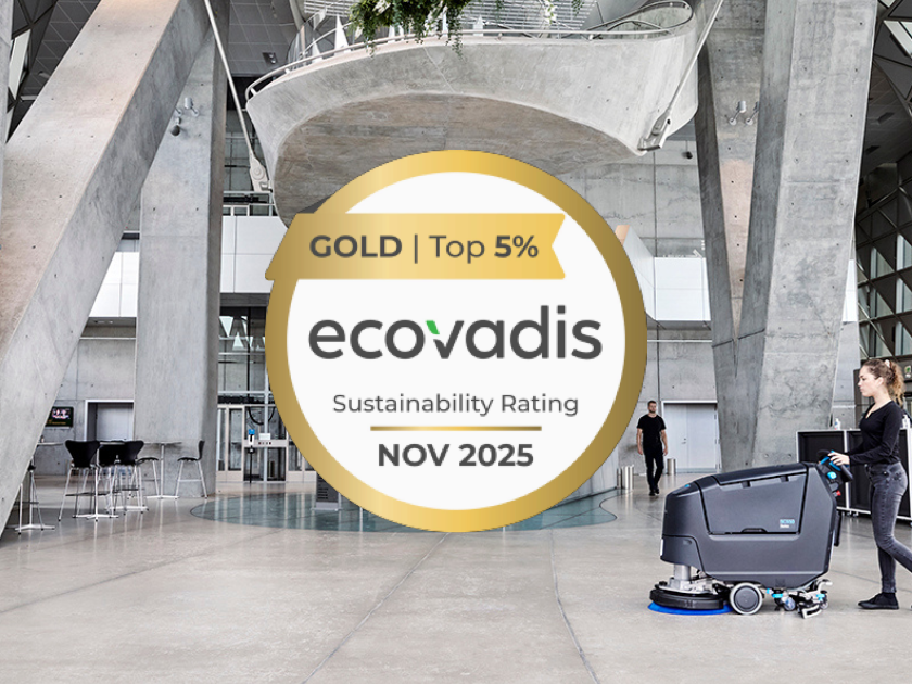 Woman operating Nilfisk floor cleaner in modern concrete space, with EcoVadis Gold Sustainability Rating badge prominently displayed.