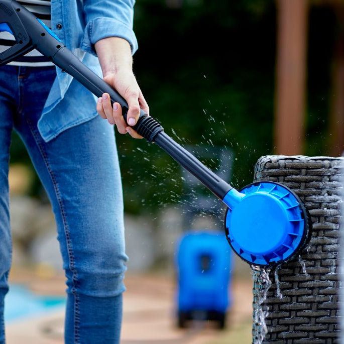 Rotating brush accessory for pressure washers, alongside denim-clad person cleaning furniture.