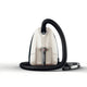 Champagne vacuum cleaner by Nilfisk with a black hose coiled around it on a white background.

