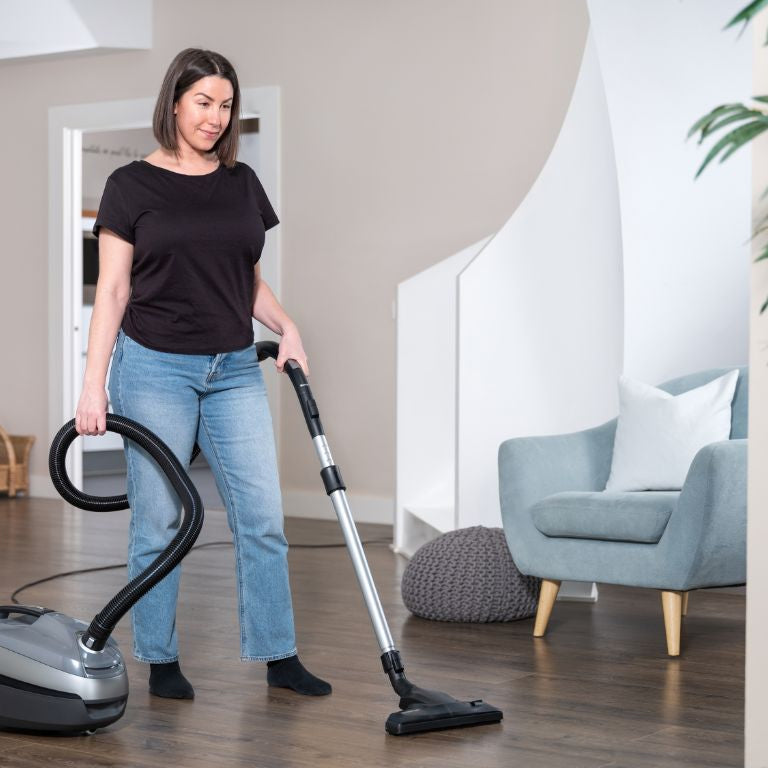 Støvsuger 650 W by ES Select on a hardwood floor in a contemporary living room.