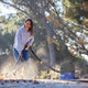 Wet and dry vacuum cleaner by Nilfisk being used to vacuum leaves outdoors, worn with a light purple hoodie and jeans.