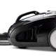 Black cylinder vacuum cleaner by Nilfisk with hose attachment and silver-tone wheel.