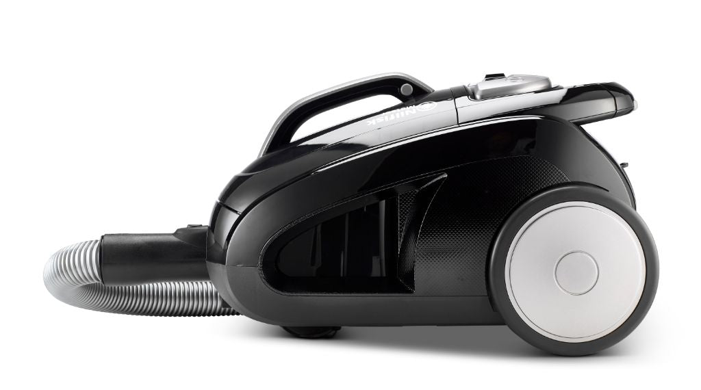 Black cylinder vacuum cleaner by Nilfisk with hose attachment and silver-tone wheel.