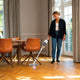 Cordless stick vacuum by HOME ES in use on a wood herringbone floor.