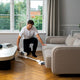 Cordless stick vacuum cleaner from HOME, with LED light and a man in a white t-shirt vacuuming.