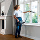 Cordless stick vacuum cleaner with LED lighting by [Vendor name], held by a woman in a living room.