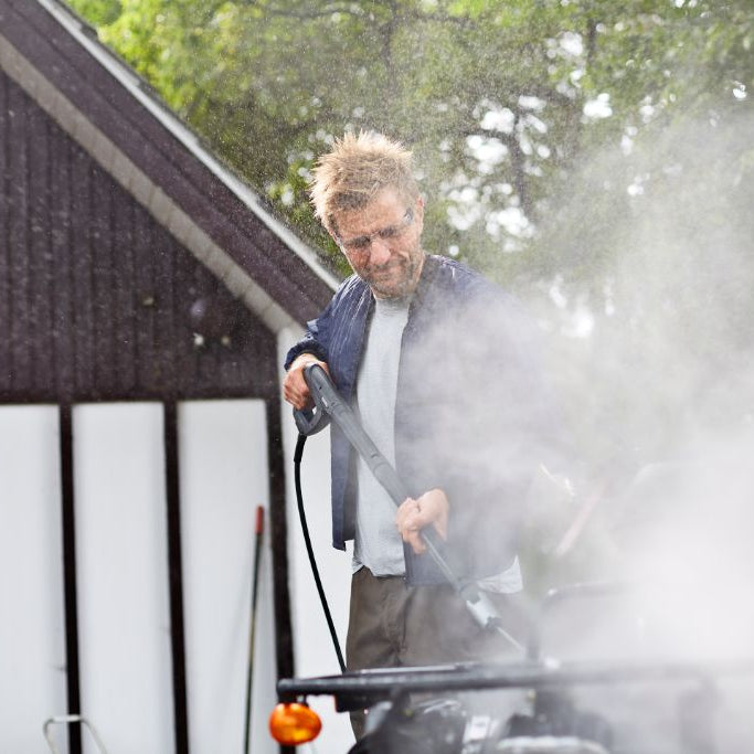Pressure washer by ES Premium being used by a man with water spraying around it.
