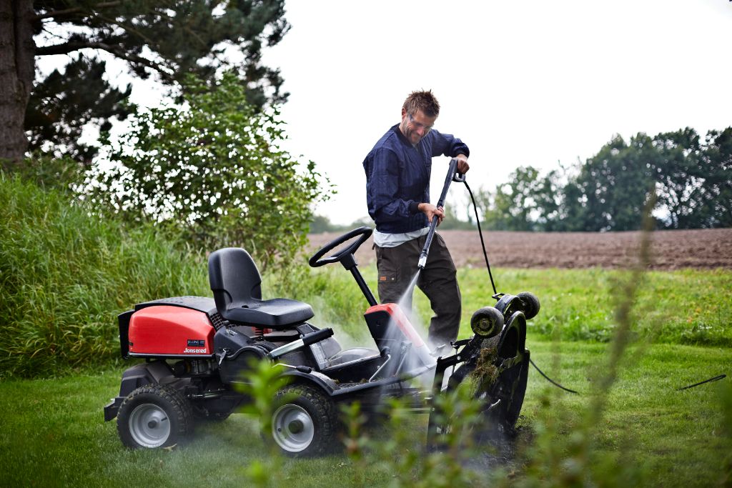 High-pressure cleaner ES Premium 200-15 Højtryksrenser, being used outdoors, by a man washing a lawnmower.