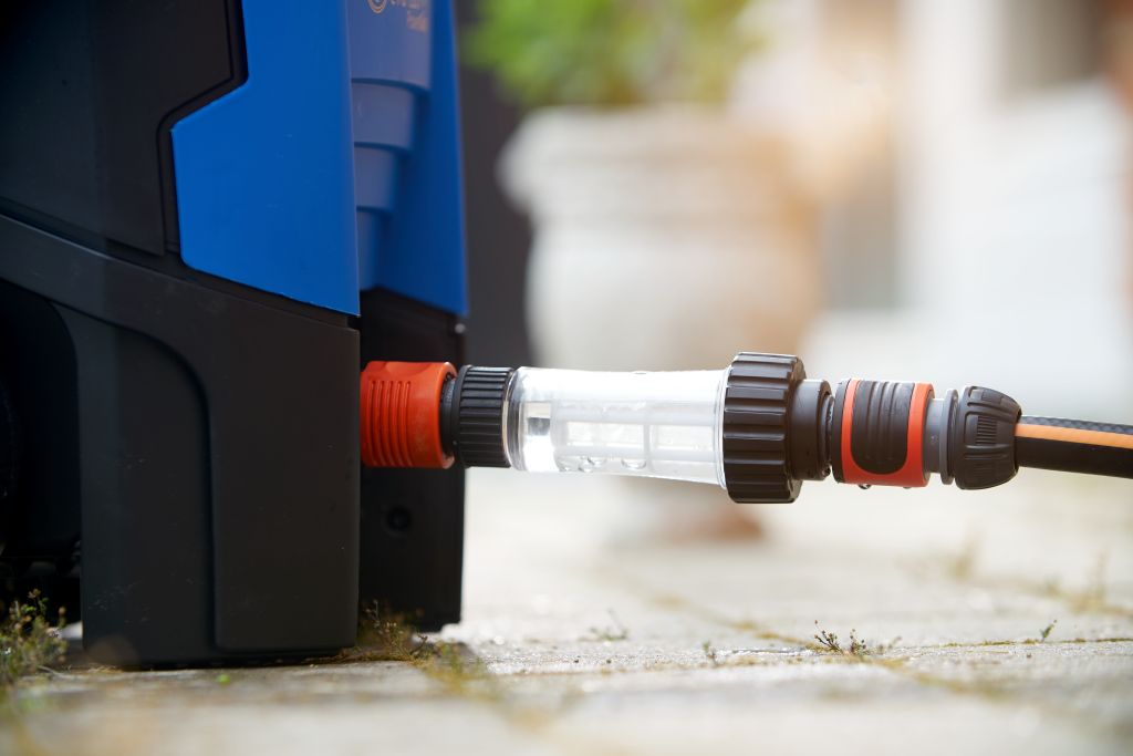 Water filter for pressure washers by Gardena, connected to a blue pressure washer.