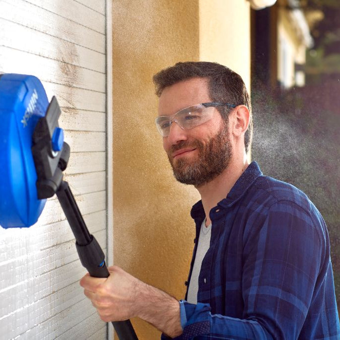 Blue patio cleaner attachment for pressure washers by ES being used on a wall