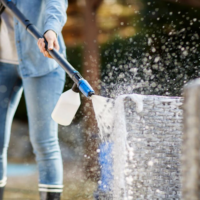 Super foam sprayer click and clean accessory, for high pressure washer, being used on a brick container.