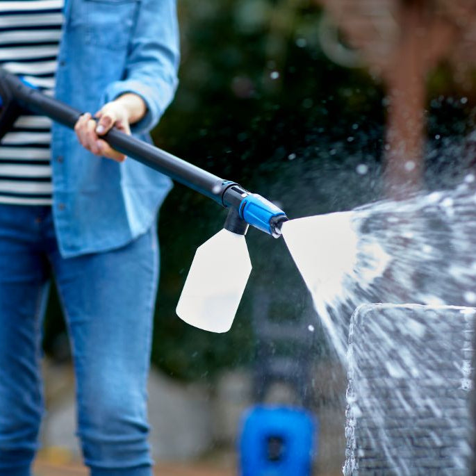 High-pressure cleaner detergent with soap dispenser, being used to clean a rattan chair.
