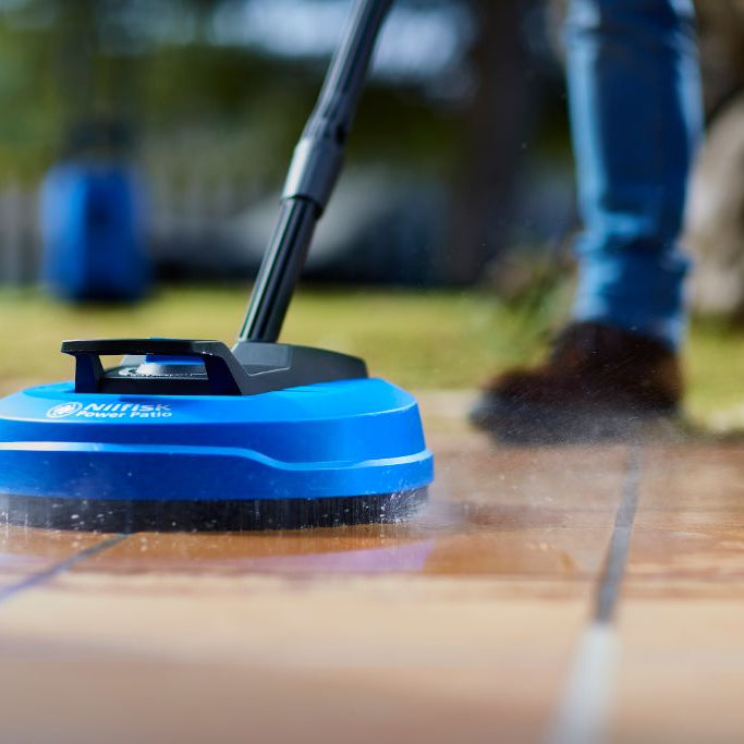 Blue power patio cleaner by Nilfisk showing a floor cleaning head in action.
