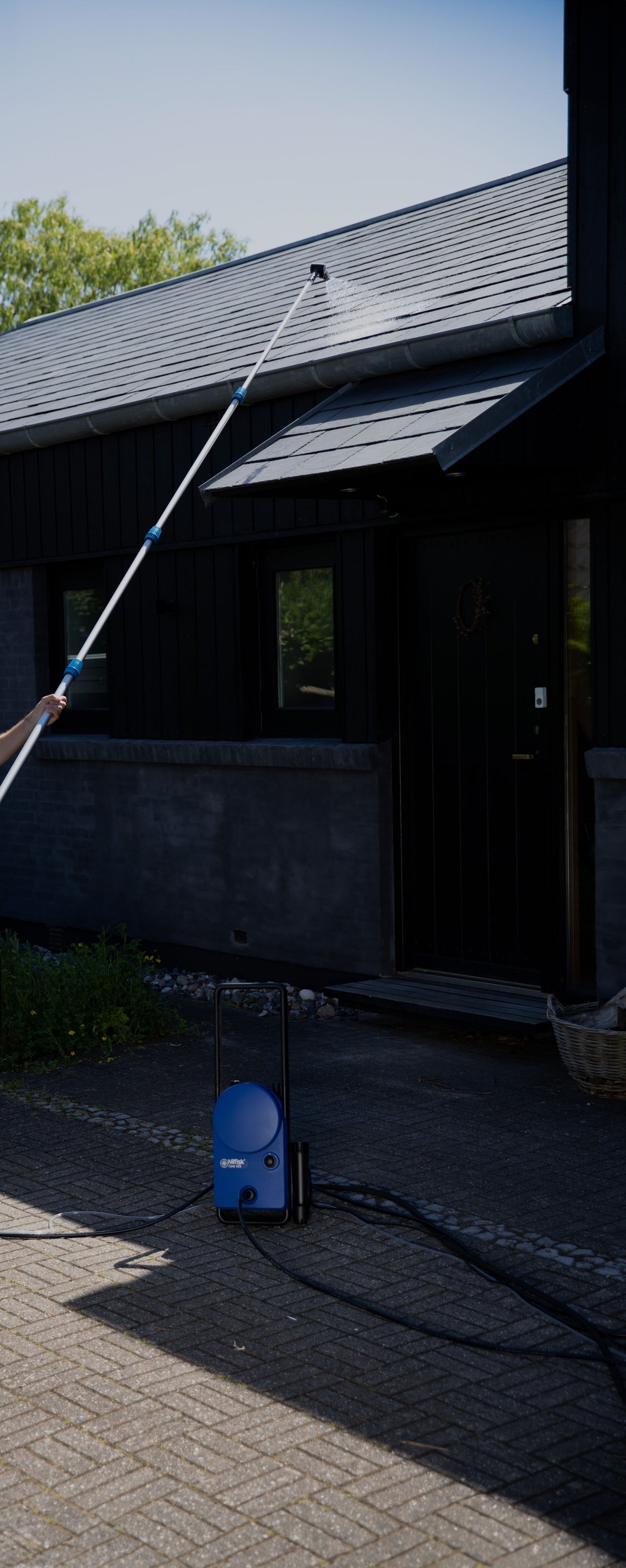 High pressure extension lance by Nilfisk with telescoping design for washing the roof of a house.