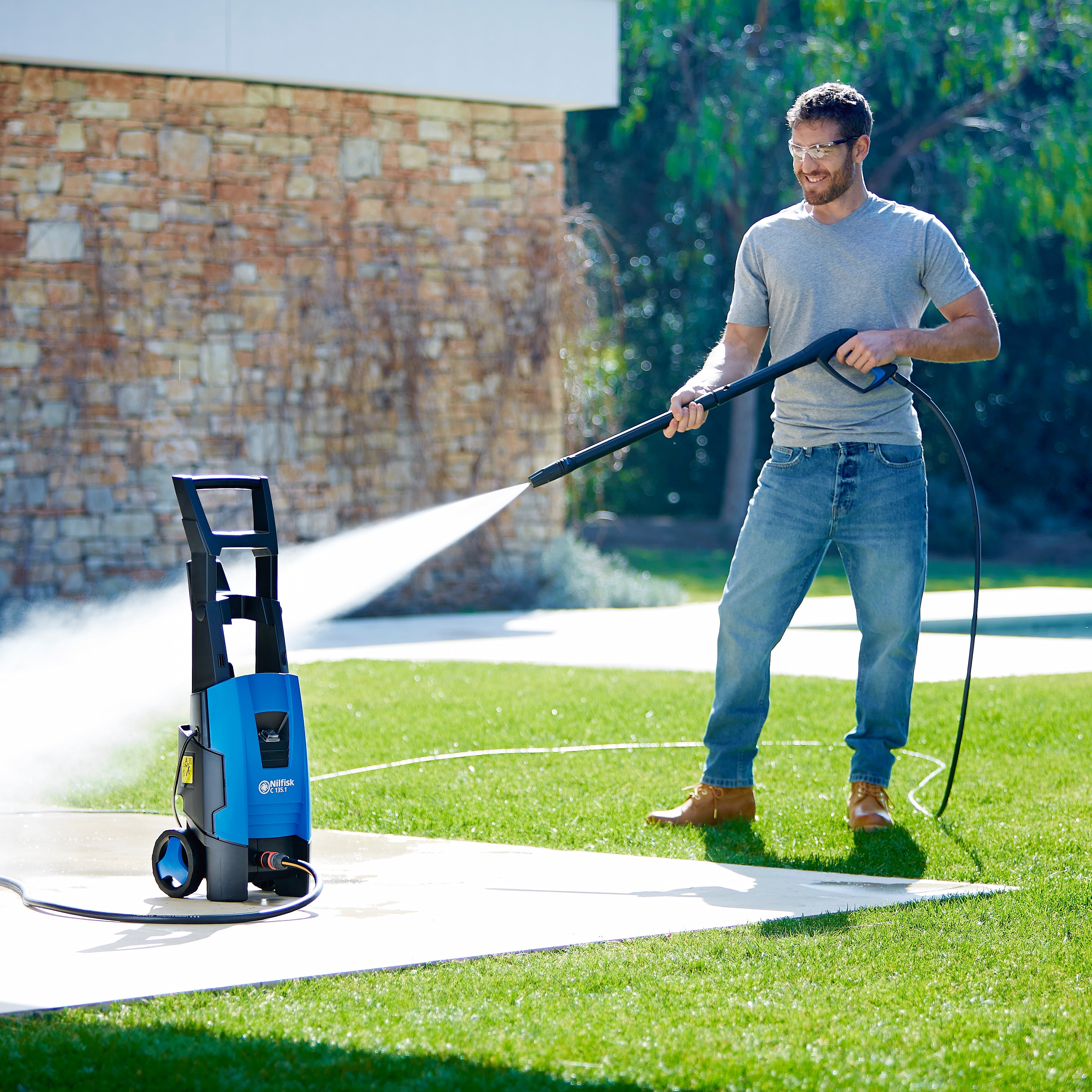 Pressure washer hose, 6m long, with spray gun in use, by ES, outdoors on a green lawn.