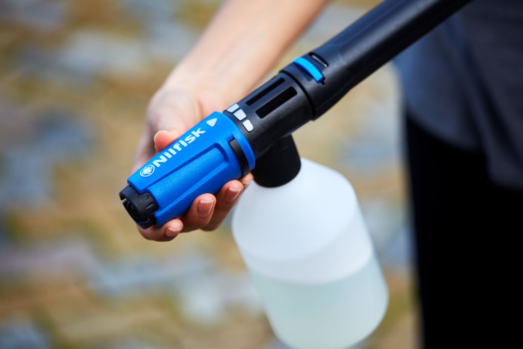 Blue car wash kit for high-pressure cleaners by Nilfisk with transparent white bottle attached.