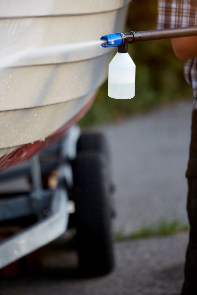 High-pressure cleaner detergent by ES Caravan & Boat Cleaner, being sprayed on a boat.
