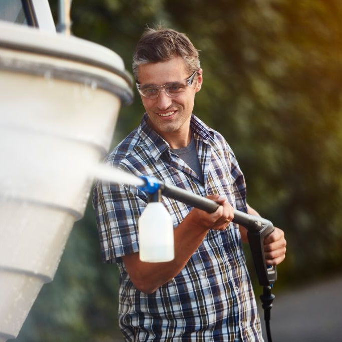 High-pressure cleaner detergent by unspecified brand being used on a boat, with a man in a plaid shirt.
