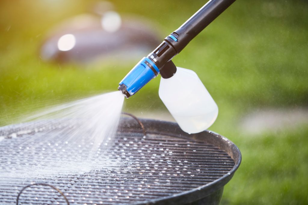 Pressure washer cleaning fluid, 2.5L, for high-pressure cleaners, shown being sprayed on a barbecue grill.
