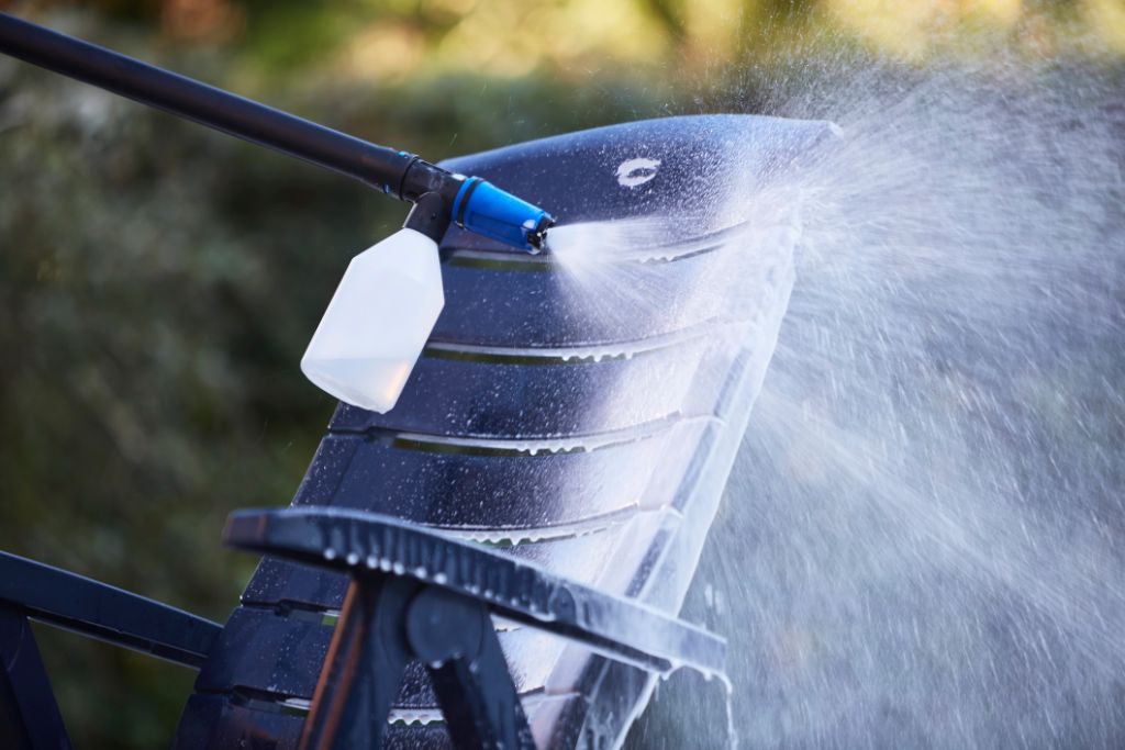 High-pressure cleaner detergent for rattan and plastic by ES cleaning a black outdoor chair.