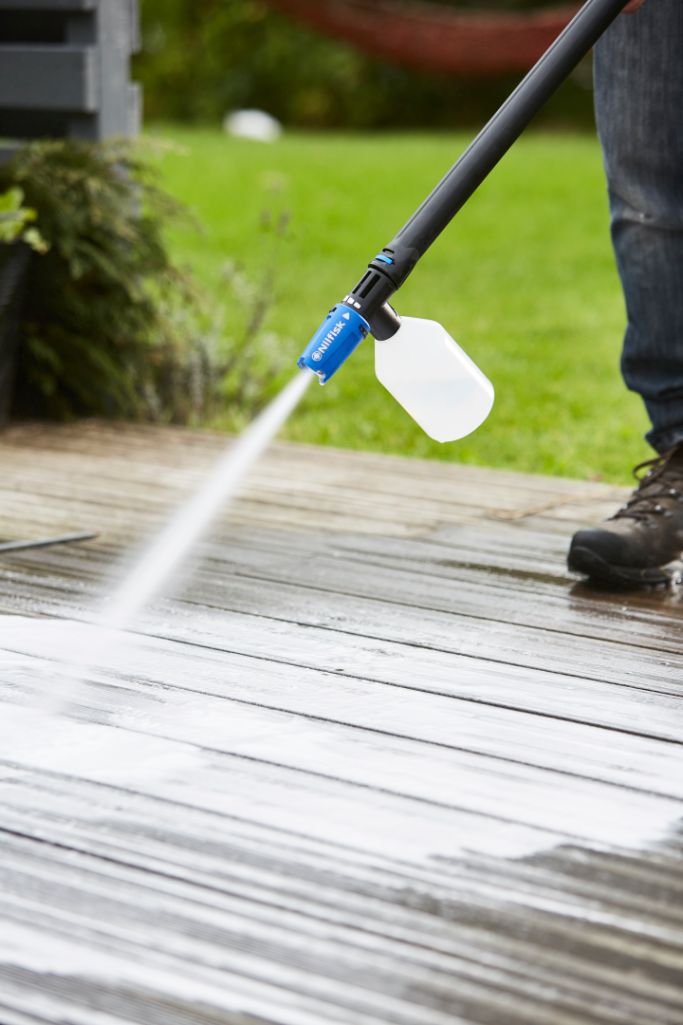 Højtryksrenser rengøringsmiddel ES Stone & Wood Cleaner without brand information spraying a wooden deck.