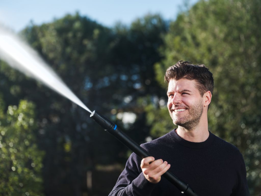 High pressure washer by ES C, being used outside with water spraying.
