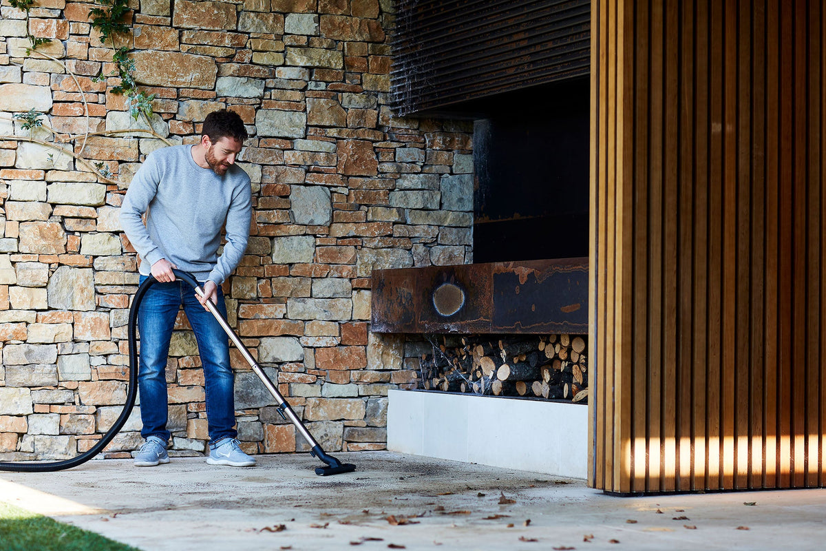 Wet and dry vacuum cleaner, 1200 W, for cleaning a patio with stone wall and outdoor fireplace.