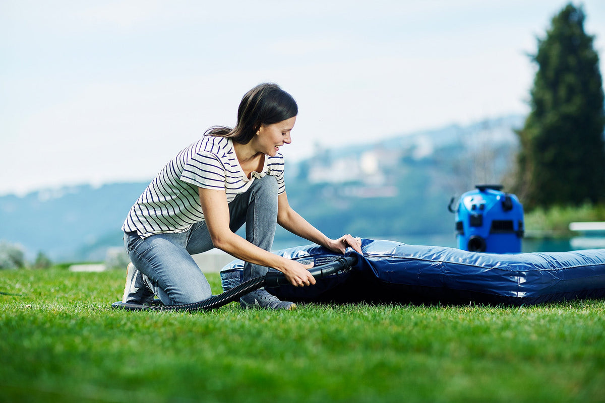 Wet and dry vacuum cleaner with floor nozzle, 1400 W, with a blue tank, near an inflatable mattress.