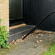 Wet/dry vacuum with floor nozzle by Nilfisk, cleaning up leaves near a doorstep.