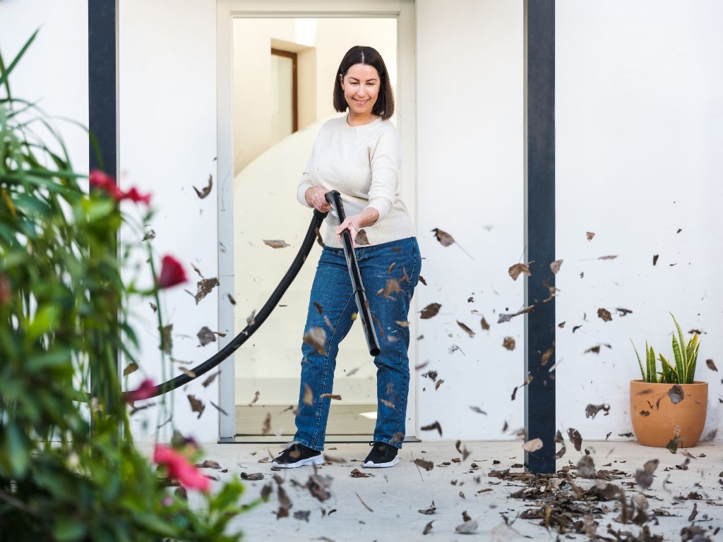Wet and dry vacuum Buddy II 18 Inox, 1200 W with leaves swirling around it.
