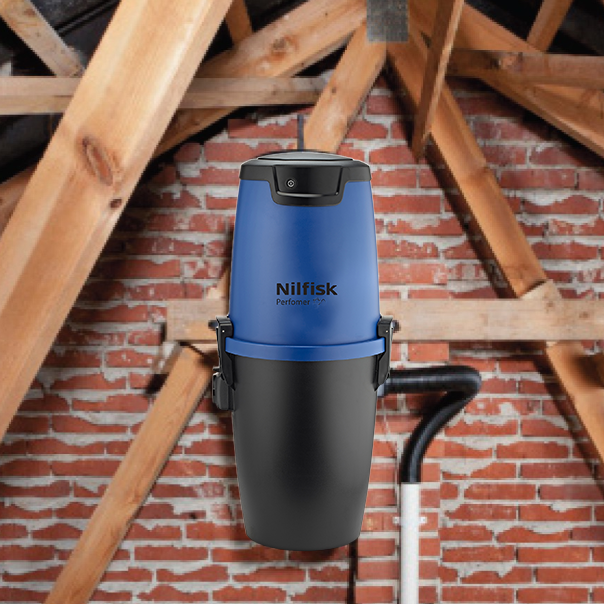 Blue and black central vacuum cleaner by Nilfisk with the hose running down out of view, in an attic.