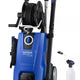 Blue pressure washer by Nilfisk, featuring a hose reel, spray gun, and accessory nozzle.