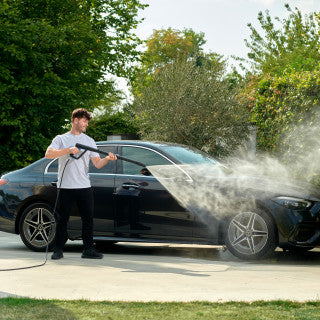 Pressure washer nozzle for G4R lance with water spraying a black car in a lifestyle shot.
