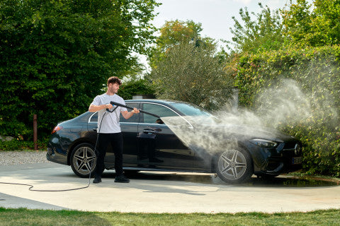 High-pressure washer spray handle from ES, being used to clean a black car.