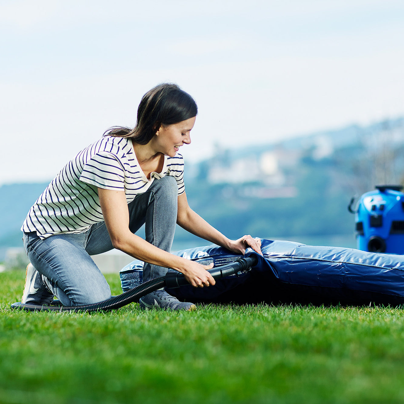 Wet and dry vacuum cleaner with floor nozzle, 1400 W, next to an inflatable pool on green grass.